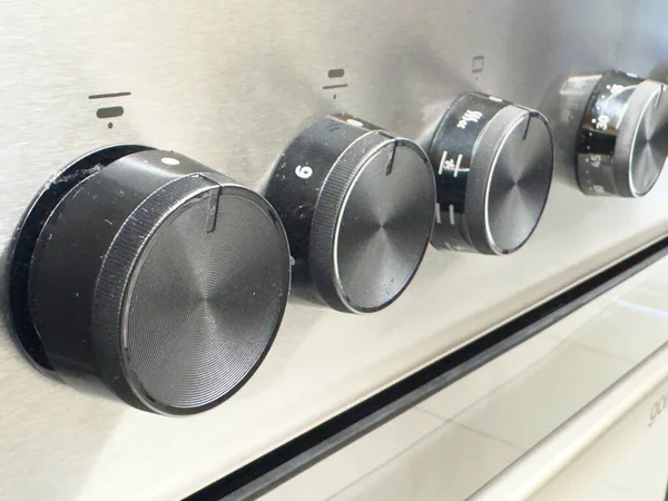 Zagreb, Hırvatistan - 17 Aralık 2025: Siyah kadranlı paslanmaz çelik fırın düğmelerinin yakın plan resmi, sıcaklık ayarları ve modern mutfak estetiği