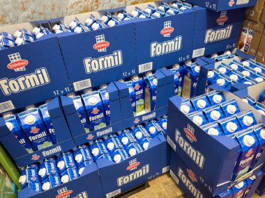 Villach, Avusturya - 13 Aralık 2025: Bir depolama alanında canlı mavi ambalaj ve fotokopi alanı ile organize düzenleme sergilenen Formil süt kutuları