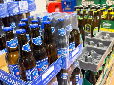 Villach, Avusturya - 13 Aralık 2025: Süpermarket raflarında düzenlenmiş Puntigamer bira şişeleri, tüketiciler için renkli ambalaj ve çeşitli seçimleri vurguluyor