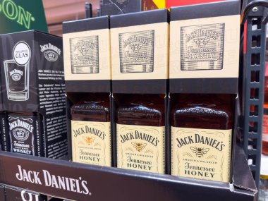 Villach, Avusturya - 13 Aralık 2025: Jack Daniel 'in Tennessee Bal viski şişeleri perakende satış rafında gösteriliyor, markanın eşsiz ambalaj ve tasarımı vurgulanıyor