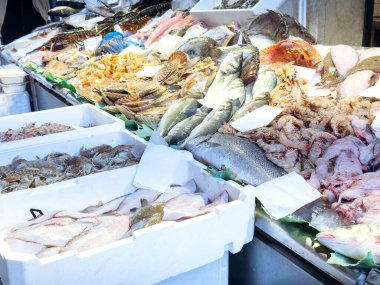 Pazarda çeşitli deniz ürünleri sergilenmektedir: taze balık, ıstakoz, buzda karides çeşitliliği.