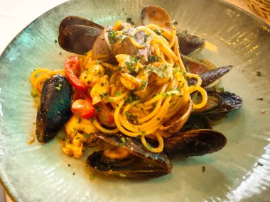 Delicious seafood spaghetti with mussels and clams in a rustic italian dish.