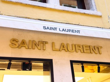 Venedik, İtalya - 05 Aralık 2025: Saint Laurent mağazasının ön tarafında, lüks moda meraklıları için mükemmel bir arka planda bulunan, altın simge logosu bulunmaktadır.