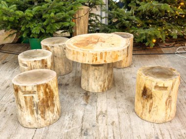 Kırsal ahşap masa ve dışarıdaki orman ortamında kurulmuş tabureler..