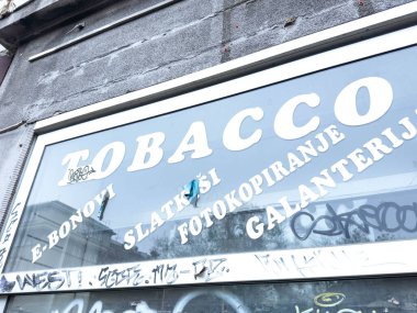 Zagreb, Hırvatistan - 14 Aralık 2025: Fotokopi hizmetleri ve grafitilerin yer aldığı tütün dükkanı penceresi, kentsel kültür ve yerel sanatsal sanatların vurgulanması