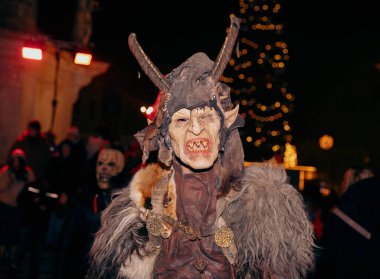 Sankt Veit A D Glan, Avusturya - 4 Ocak 2025: Krampuslauf etkinliği, bayram ışıkları ve coşkulu kalabalıkla şenlikli bir atmosferde boynuzlu bir şahsiyet sergiliyor