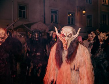 Sankt Veit A D Glan, Avusturya - 4 Ocak 2025: Krampuslauf etkinliği, maskeli ve kürklü kostümlü katılımcıları ön plana çıkararak, şenlikli ama ürkütücü bir kış kutlaması sahnesi yarattı