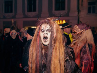 Sankt Veit A D Glan, Avusturya - 4 Ocak 2025: Krampuslauf etkinliğinde boynuzlu ve makyajlı bir kadın canlı bir bayram kutlamasına daldı