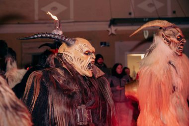 Sankt Veit A D Glan, Avusturya - 4 Ocak 2025: Krampuslauf etkinliği, boynuzlu ve karmaşık kostümler giyen erkeklerin, şenlikli bir kış ortamı yaratarak sergilenmesi