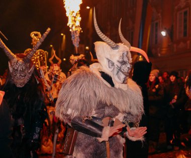 Sankt Veit A D Glan, Avusturya - 4 Ocak 2025: Krampuslauf etkinliği, özenli kostümlü boynuzlu figürler, alevler ve seyircilerle canlı bir kış ortamı yarattı
