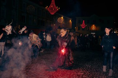 Sankt Veit A D Glan, Avusturya - 4 Ocak 2025: Krampuslauf kutlamaları, festival dekorasyonları ve coşkulu kalabalıkla çevrili, ayrıntılı kostüm ve maskelerle katılımcıları sergiliyor