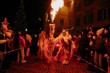 Sankt Veit A D Glan, Avusturya - 4 Ocak 2025: Krampuslauf etkinliği alevler içinde karmaşık kostümler içinde gösteri yapan katılımcılar, canlı bir kış atmosferinde seyircileri büyüledi