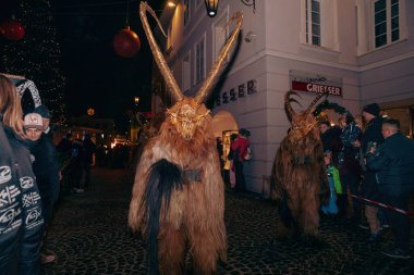 Sankt Veit A D Glan, Avusturya - 4 Ocak 2025: Krampuslauf kutlamaları kürk kostümlü, neşeli dekorasyonlar ve heyecanlı bir kalabalıkla çevrili, boynuzlu figürler sergiledi