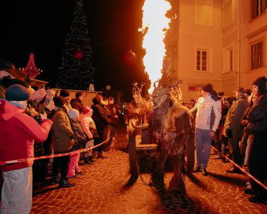 Sankt Veit A D Glan, Avusturya - 4 Ocak 2025: Krampuslauf kutlamalarında alevler içindeki kostümlü bir şahıs, bayram etkinlikleri sırasında heyecanlı bir kalabalığı büyüledi