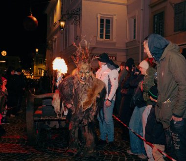 Sankt Veit A D Glan, Avusturya - 4 Ocak 2025: Krampuslauf kutlamaları, canlı bir gecede kalabalığı büyüleyen alevli boynuzlu bir figürü sergiliyor