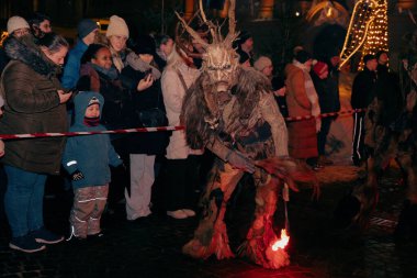 Sankt Veit A D Glan, Avusturya - 4 Ocak 2025: Krampuslauf etkinliği kürklü boynuzlu bir yaratığı, fotokopi uzayı ile hareketli bir atmosferde izleyicileri cezbediyor.