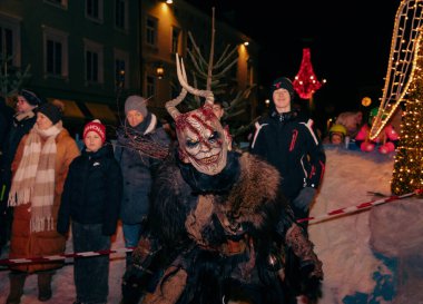 Sankt Veit A D Glan, Avusturya - 4 Ocak 2025: Krampuslauf kutlamaları dramatik bir kostüm içindeki boynuzlu bir figürü sergiliyor.