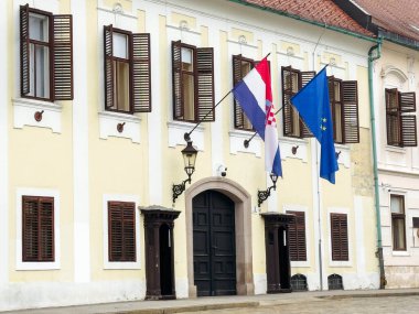 Zagreb, Hırvatistan - 16 Aralık 2025: Kültür mirası ve kentsel cazibeyi temsil eden sarı dış kaplama, ahşap panjurlar ve bayraklarla tarihi yapı