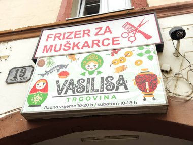 Zagreb, Hırvatistan - 16 Aralık 2025: Berber dükkanı tabelası canlı grafikler ve metinler göstererek, yerel kültür ve gelenekleri tasarım için kopya alanı ile ön plana çıkarıyor