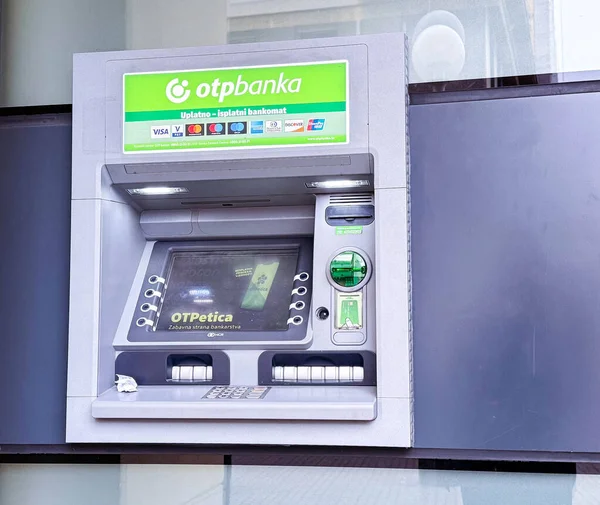 Zagreb, Hırvatistan - 16 Aralık 2025: OTP Bank 'tan ATM makinesi, ışıklandırılmış arayüzle tasarlandı, reklam için geniş bir kopya alanı ile kentsel ortamda konumlandırıldı