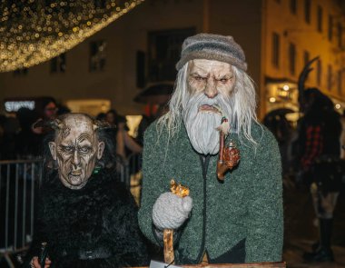 Villach, Avusturya - 01 Aralık 2023: Krampuslauf kutlamaları Krampus 'un özenle hazırlanmış kostümleri içindeki sanatçıları ön plana çıkararak, tatil sezonunda canlı ve şenlikli bir ortam yarattı.