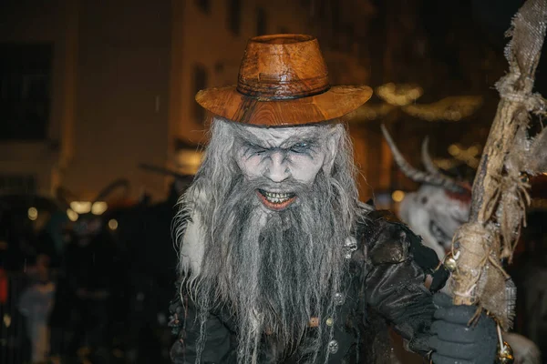 Villach, Avusturya - 01 Aralık 2023: Krampuslauf festivali, ahşap şapkası ve asası olan ve folkloru kopyalama alanı ile dolu canlı bir sokak atmosferinde somutlaştıran korkunç bir karakteri sergiledi.