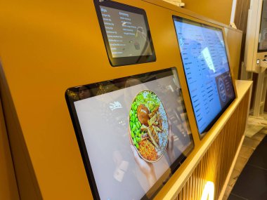 Zagreb, Hırvatistan - 17 Aralık 2025: Dijital menü ekranında, bir restoran ortamında modern yemek ve teknolojinin vurgulandığı, çeşitli malzemelere sahip renkli bir yemek yer alıyor