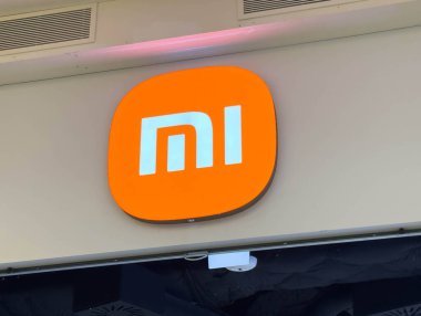 Zagreb, Hırvatistan - 17 Aralık 2025: Xiaomi logosu parlak turuncu arkaplana karşı durarak, kopya alanı olan bir perakende satış ortamında marka kimliği ve yeniliği vurguluyor