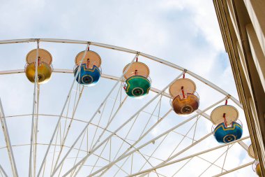Bir lunaparkta bulutlu gökyüzüne karşı renkli dönme dolap.