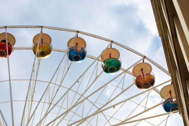 Mimari çizgileri olan bulutlu gökyüzüne karşı renkli dönme dolap..