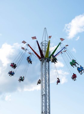 Villach, Avusturya - 29 Temmuz 2025: Renkli salıncak sürücüleri açık gökyüzü ile canlı bir festival atmosferinde heyecan verici deneyimin tadını çıkarıyorlar