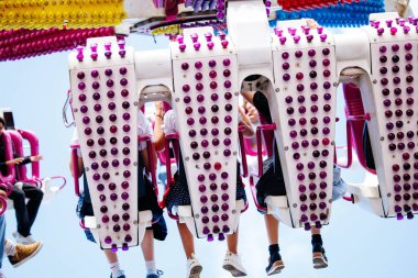 Villach, Avusturya - 29 Temmuz 2025: Heyecanlı sürücüler renkli koltukları ve neşeli atmosferi olan canlı bir festivalde heyecan verici bir eğlence turu yaşıyorlar