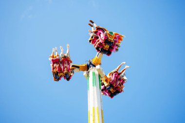Villach, Avusturya - 29 Temmuz 2025: Eğlence parkı gezisi, heyecan dolu sürücülerin fotokopi uzayı ile kutlamalarında yaşadıkları sevinç ve heyecan ile yukarıda dönüyor