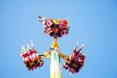 Villach, Avusturya - 29 Temmuz 2025: Villacher Kirchtag 'da eğlence parkı gezisi canlı mavi gökyüzüne karşı heyecan verici deneyimin tadını çıkaran sürücüler