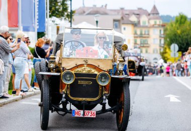 Velden, Avusturya - 30 Ağustos 2025: Klasik klasik arabalar, Eski Zaman Festivali deneyiminin keyfini çıkaran heyecanlı kalabalıkların katıldığı canlı bir geçit töreninde sergileniyor