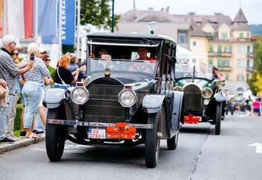 Velden, Avusturya - 30 Ağustos 2025: Antika araba klasik tasarım ve nostaljik atmosfer sergileyerek Eski Zaman Festivali 'nde heyecanlı kalabalığın yanından geçti