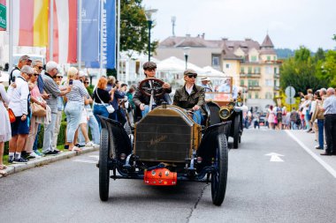 Velden, Avusturya - 30 Ağustos 2025: Klasik araba meraklıları Oldtimer Festivali 'nde antika bir otomobil kullanıyor, izleyiciler canlı atmosferin keyfini çıkarıyor