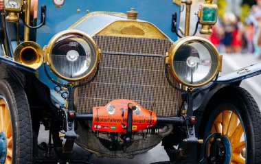 Velden, Avusturya - 30 Ağustos 2025: Pirinç detayları ve klasik farların yer aldığı klasik araba, bir Eski Zaman Festivali 'nde sergileniyor, otomotiv tarihi ve zanaatkarlığı sergileniyor