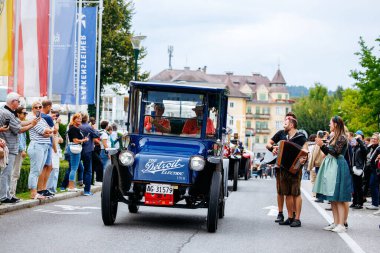 Velden, Avusturya - 30 Ağustos 2025: Klasik Detroit Elektrikli araç festival caddesi boyunca sürerken, kalabalık eski zamanların kutlaması ve hareketli ambiyansın keyfini çıkarıyor