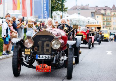 Velden, Avusturya - 30 Ağustos 2025: Klasik klasik arabalar canlı bir geçit töreninde sergilendi, izleyiciler festival atmosferinin ve el sallayan ellerin keyfini çıkardılar