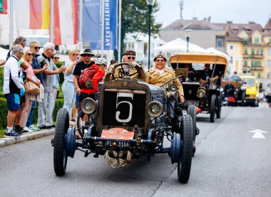 Velden, Avusturya - 30 Ağustos 2025: Klasik klasik arabalar, Eski Zaman Festivali sırasında sokak boyunca heyecanlı izleyicilerle canlı bir geçit töreninde sergileniyor