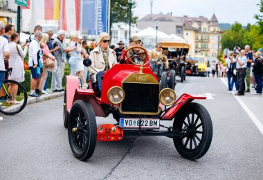Velden, Avusturya - 30 Ağustos 2025: Klasik Ford Model T otomobili, klasik otomotiv atmosferinin keyfini çıkaran coşkulu izleyicilerle Oldtimer Festivali 'nde belirgin bir şekilde sergileniyor