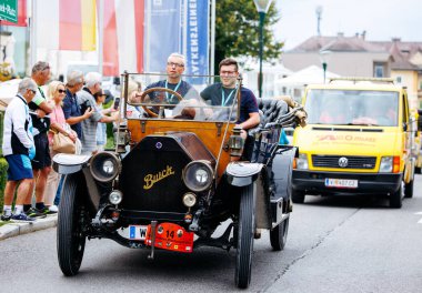 Velden, Avusturya - 30 Ağustos 2025: Antika Buick arabası, klasik araçlara ve canlı dekorasyonlara hayran olan heyecanlı kalabalıkla Oldtimer Festivali 'nde geziyor