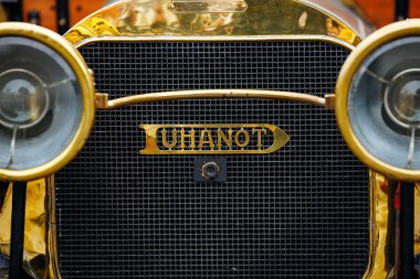 Velden, Avusturya - 30 Ağustos 2025: Parlak altın detayları ve yuvarlak farların yer aldığı klasik otomotiv tasarımının ön görüntüsü