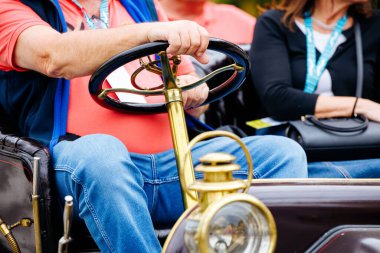 Velden, Avusturya - 30 Ağustos 2025: Klasik araba sevdalısı, otomotiv tarihi ve toplum ruhunun özünü yakalayan klasik araç direksiyonuna sahip