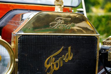 Velden, Avusturya - 30 Ağustos 2025: Vintage Ford araba ızgarası, yemyeşil bir yeşillikle çevrili bir Eski Zaman Festivali 'nde ikonik logo ve işçiliği ön plana çıkarıyor