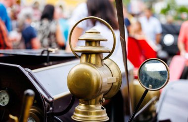 Velden, Avusturya - 30 Ağustos 2025: Klasik araba feneri ve aynası, Eski Zaman Festivali atmosferinin keyfini çıkaran canlı bir kalabalıkla ön plana çıktı