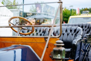Velden, Avusturya - 30 Ağustos 2025: Eski arabanın içi lüks deri koltuklar ve Oldtimer Festivali 'nde metin için fotokopi alanı olan klasik bir ahşap direksiyon simidi içeriyor