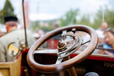 Velden, Avusturya - 30 Ağustos 2025: Oldtimer Festivali 'nde klasik direksiyon simidine yakın çekim, işçilik ve tasarım, bulanık kalabalıkla canlı bir atmosfer yaratmak