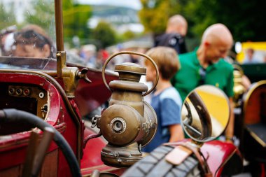 Velden, Avusturya - 30 Ağustos 2025: Otomotiv mirası ve atmosferinin keyfini çıkaran katılımcılarla çevrili klasik far odaklı klasik araba festivali